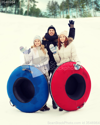 Image of group of smiling friends with snow tubes