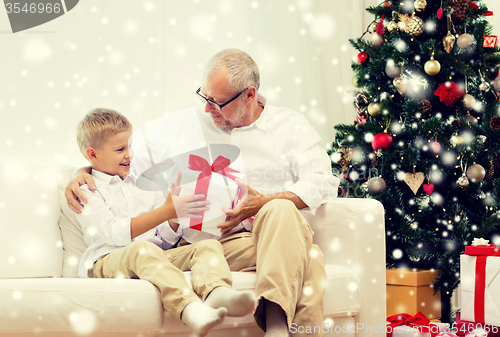 Image of smiling grandfather and grandson at home