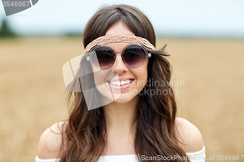 Image of smiling young hippie woman in sunglasses outdoors