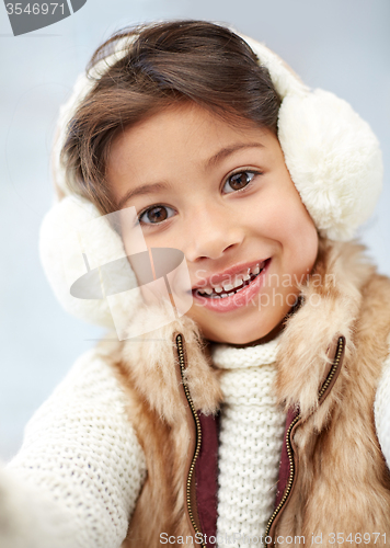 Image of happy little girl wearing earmuffs