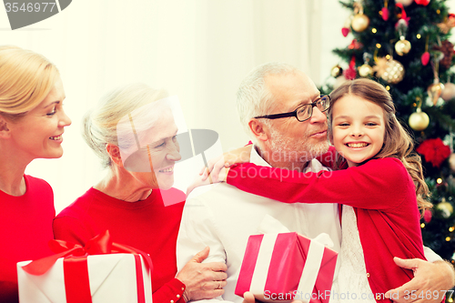 Image of smiling family with gifts at home