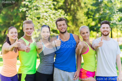 Image of group of happy sporty friends showing thumbs up