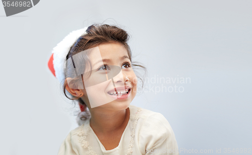 Image of happy little girl in santa hat over gray