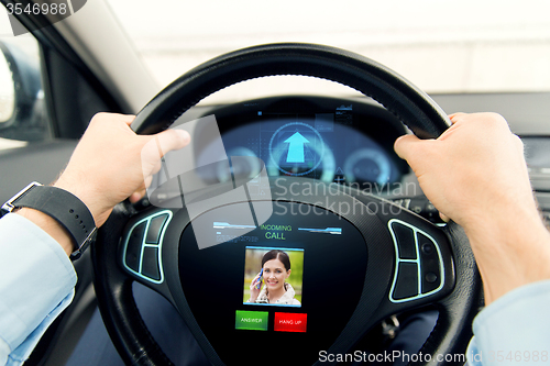 Image of close up of man driving car with incoming call