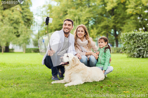 Image of happy family with dog taking selfie by smartphone