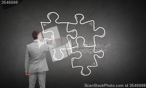 Image of businessman drawing puzzle