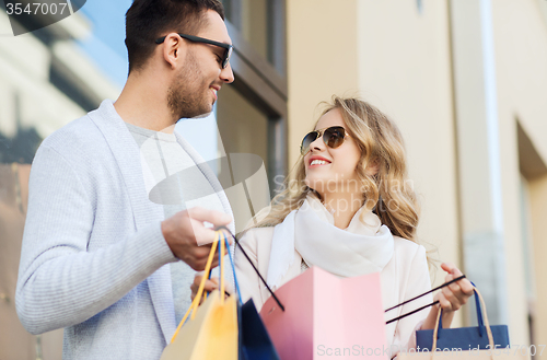Image of happy couple with shopping bags on city street