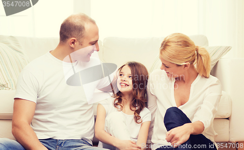 Image of parents and little girl sitting on floor at home