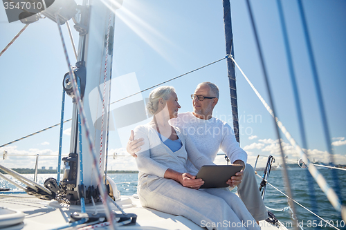 Image of senior couple with tablet pc on sail boat or yacht