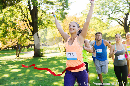 Image of happy young female runner winning on race finish