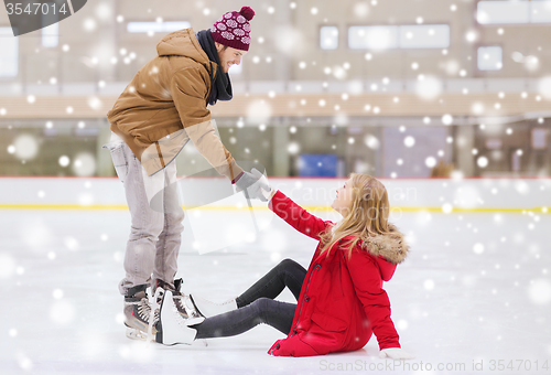 Image of man helping women to rise up on skating rink