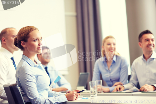 Image of group of smiling businesspeople meeting in office