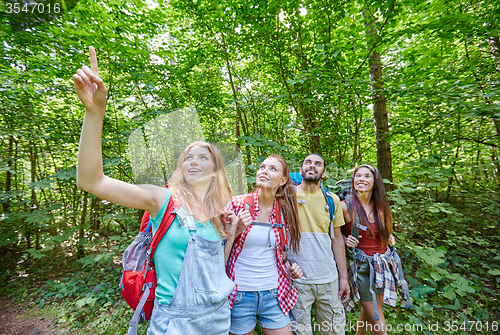 Image of group of smiling friends with backpacks hiking