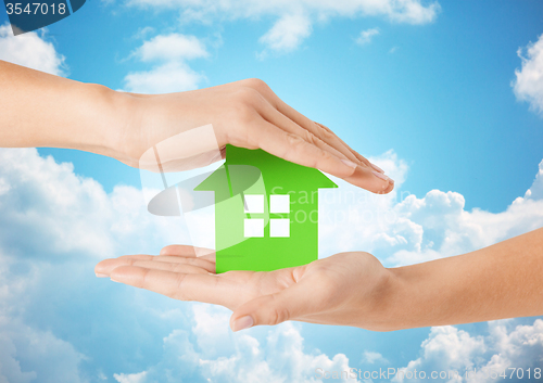 Image of close up of woman hands holding green house