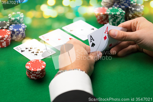 Image of poker player with cards and chips at casino