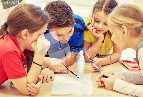 Image of group of students talking and writing at school