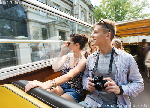 Image of smiling couple with camera traveling by tour bus