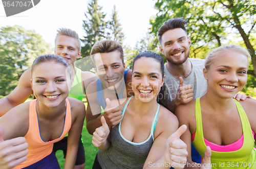 Image of group of happy sporty friends showing thumbs up