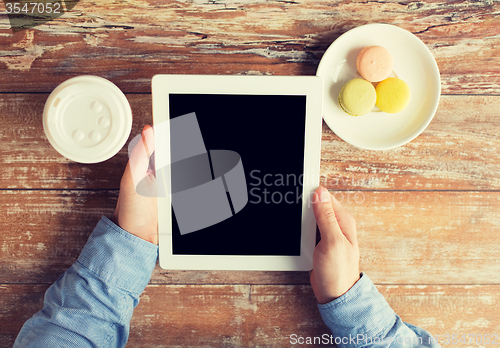 Image of close up of male hands with tablet pc and coffee