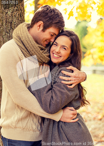 Image of smiling couple hugging in autumn park