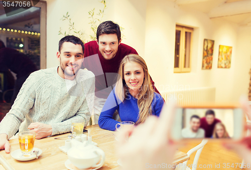 Image of group of friends taking picture with smartphone