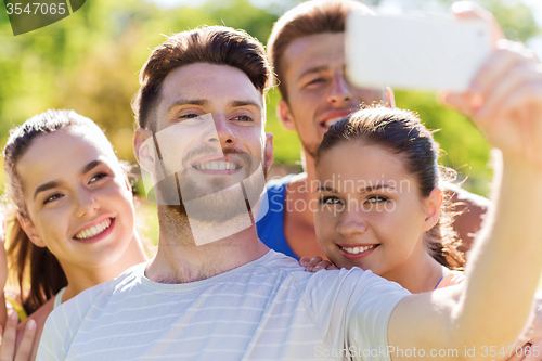 Image of happy friends taking selfie with smartphone