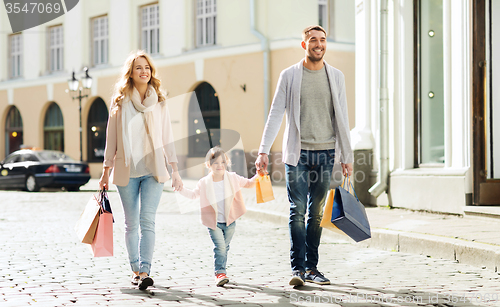 Image of happy family with child and shopping bags in city