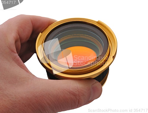 Image of Gold lens in hand, isolated