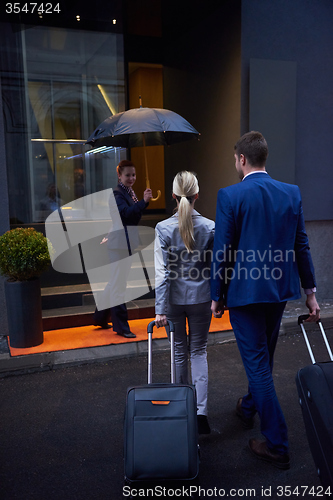 Image of business people couple entering  hotel