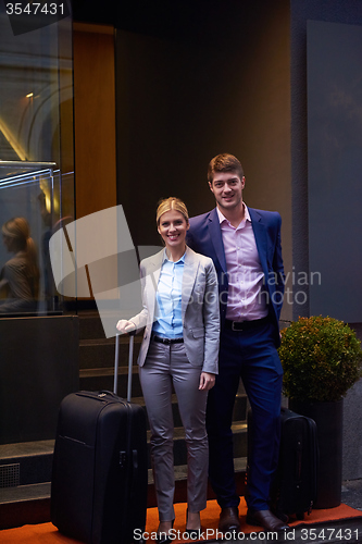 Image of business people couple entering  hotel