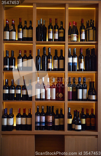 Image of Wine bottles on a wooden shelf.