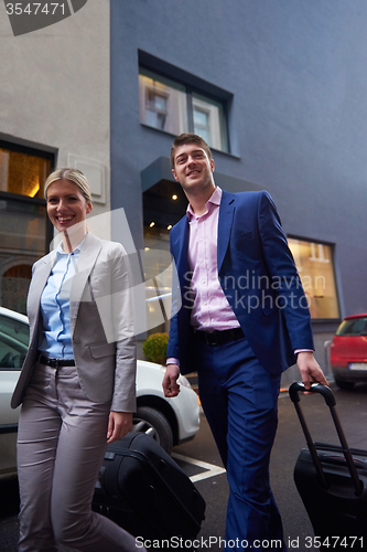 Image of business people couple entering  hotel