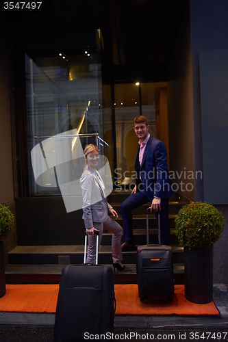 Image of business people couple entering  hotel