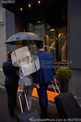 Image of business people couple entering  hotel