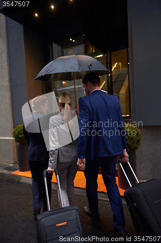 Image of business people couple entering  hotel