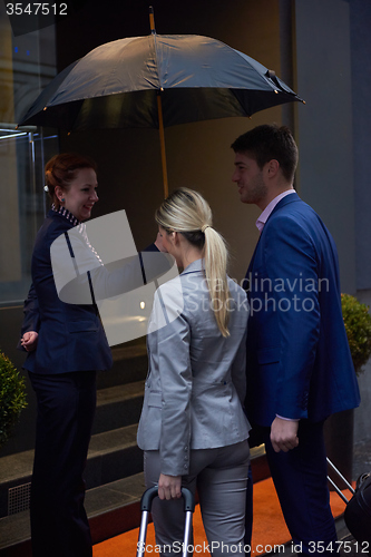 Image of business people couple entering  hotel