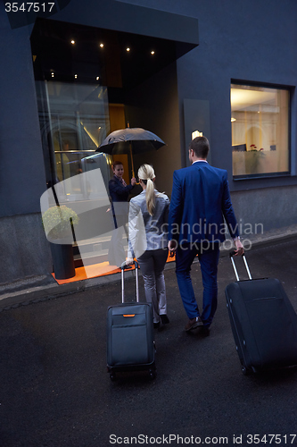 Image of business people couple entering  hotel