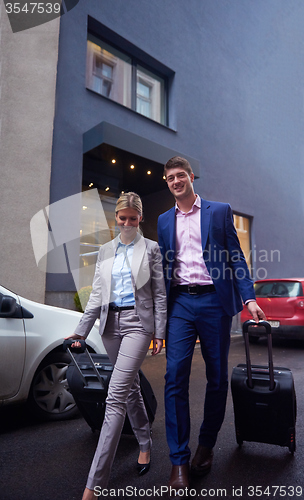 Image of business people couple entering  hotel