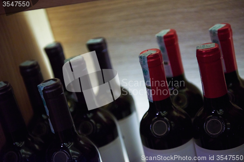 Image of Wine bottles on a wooden shelf.