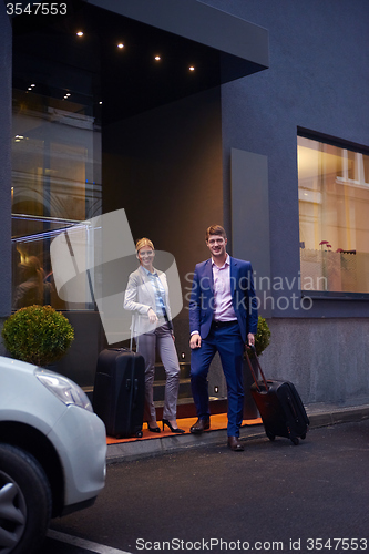 Image of business people couple entering  hotel