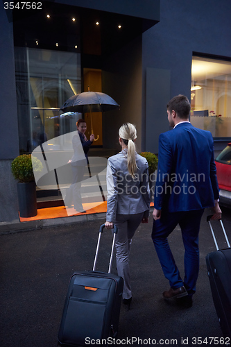 Image of business people couple entering  hotel