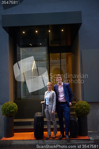 Image of business people couple entering  hotel