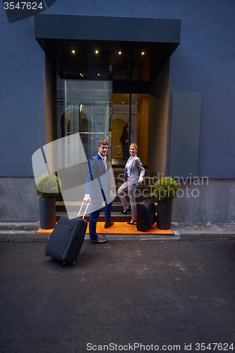 Image of business people couple entering  hotel