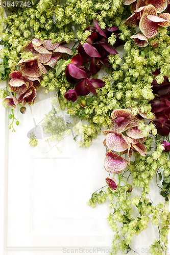 Image of ikebana from flowers and leaves on white