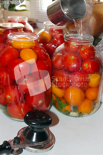 Image of tomatoes in the jars prepared for preservation
