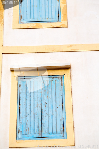 Image of blue window in  and brown wall  construction