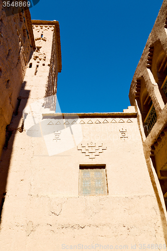 Image of blue window in  and brown construction