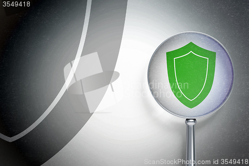 Image of Security concept:  Shield with optical glass on digital background