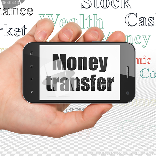 Image of Currency concept: Hand Holding Smartphone with Money Transfer on display