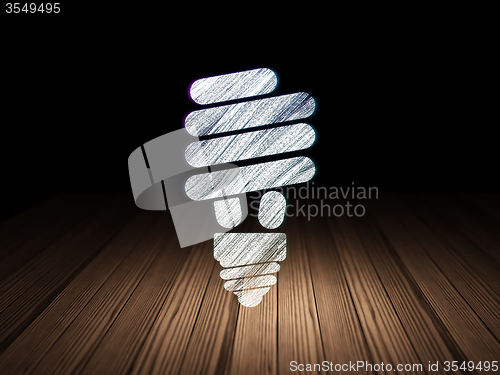 Image of Finance concept: Energy Saving Lamp in grunge dark room